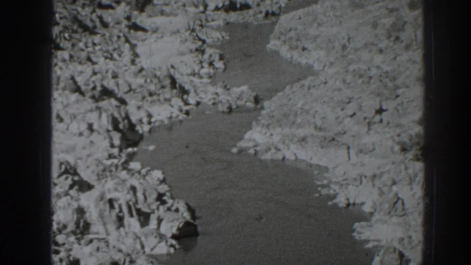 1938 8mm frame showing a river bend and rocky banks in the Oroville, California region, with soft focus and visible film texture.