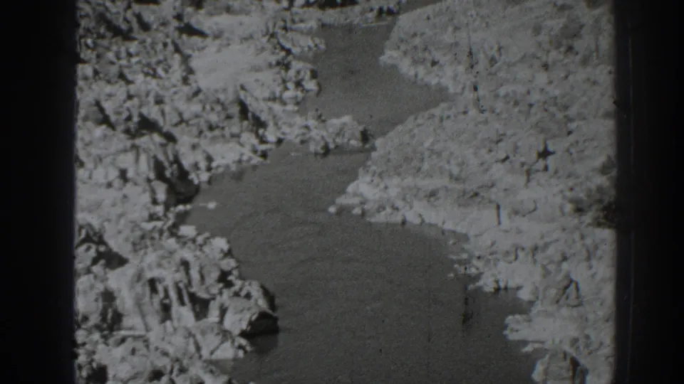 Late-1930s Oroville-area 8mm frame showing the same rocky river landscape from a similar elevated view, with visible grain and exposure variation.