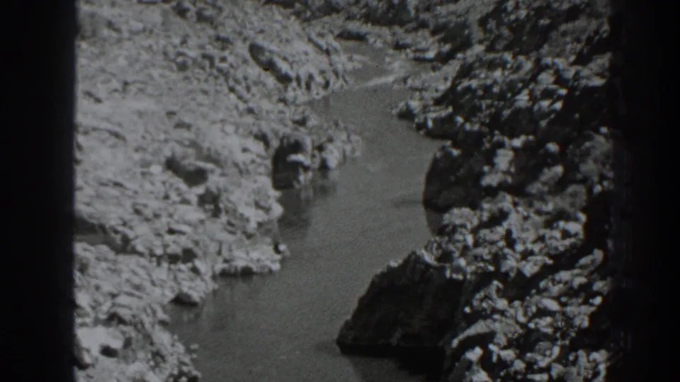 Black-and-white 8mm view near Oroville, California, with water passing between rugged canyon rocks.