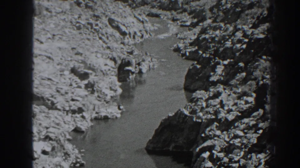 1938 Oroville-area home-movie frame showing a river bend enclosed by uneven rock formations.