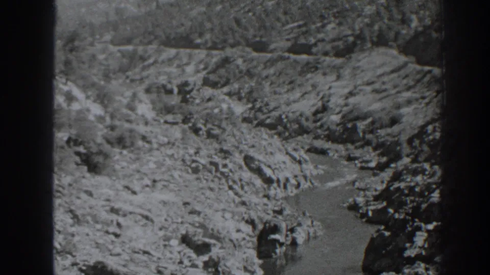 Archival 8mm frame of the Oroville-area canyon stream, with water visible among rocks and steep banks.