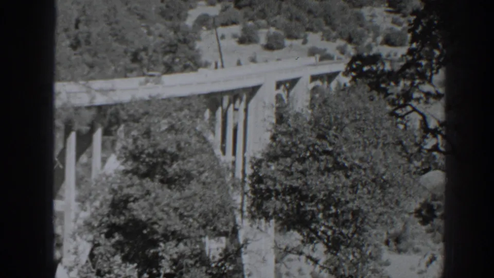 1938 Oroville-area 8mm frame showing a bridge among trees and hills, with contact-sheet borders from the film scan.