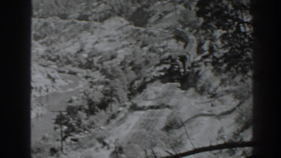A 1938 home-movie view shows the river canyon and rail route, with trees and steep terrain filling the frame.