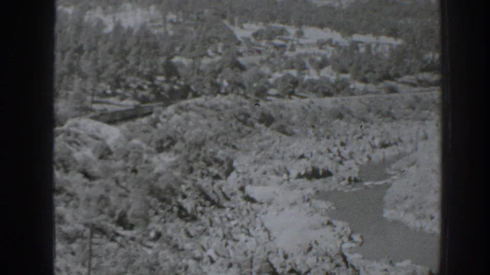 1938 Oroville, California 8mm frame showing a high-angle view of the river corridor, rocky banks, trees, and rail route.