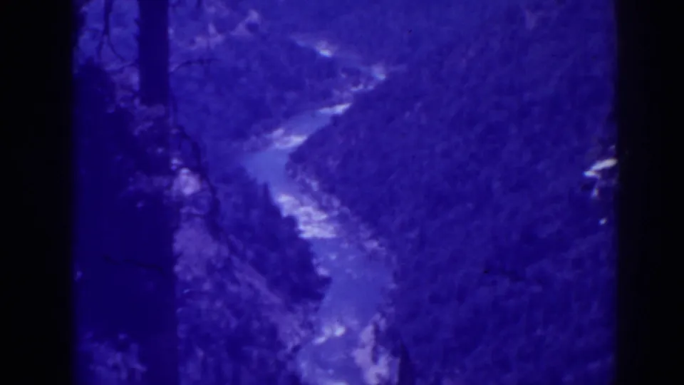 Blue-tinted 1938 Oroville, California 8mm view of a river in a dense valley, with visible grain and gate edges.
