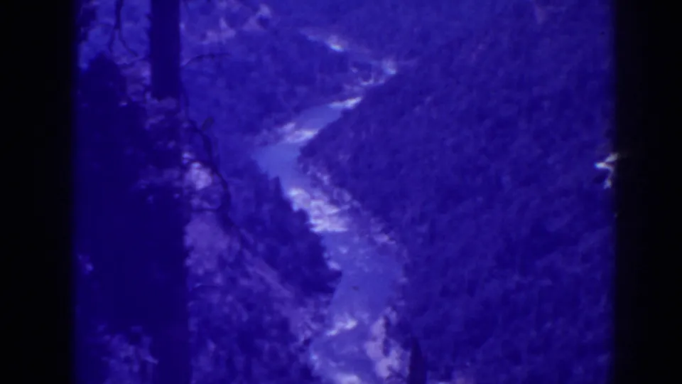 1938 Oroville-area 8mm frame showing a river curve below tree-covered hills, with visible grain and soft handheld framing.