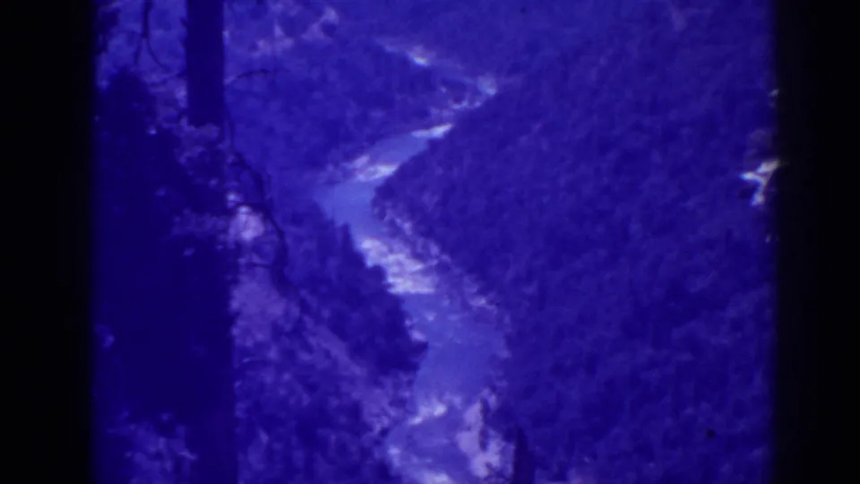 1938 Oroville-area 8mm frame with a winding river, wooded valley walls, and strong blue aging or filter coloration.