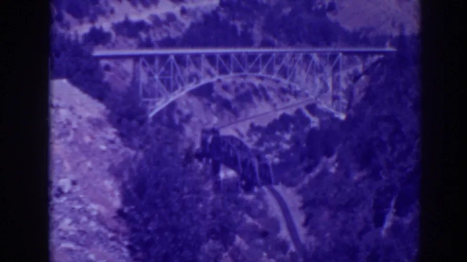 1938 Oroville-area home-movie frame of bridges crossing Feather River Canyon, tinted purple by aged 8mm film.