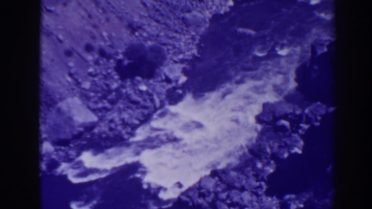 Rushing water flows through rocks with a strong purple-blue film cast.