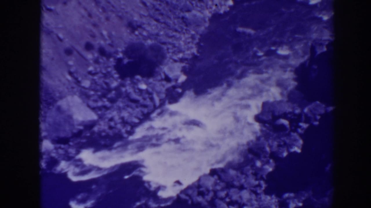 White water runs across a rocky stream bed in soft focus.