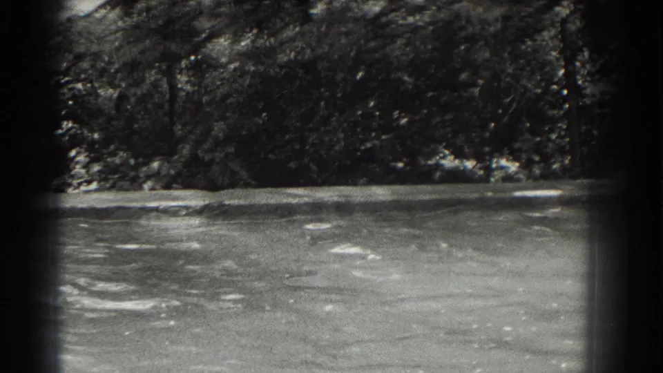 An outdoor pool and shaded trees appear in a grainy 1937 Southampton home-movie frame.