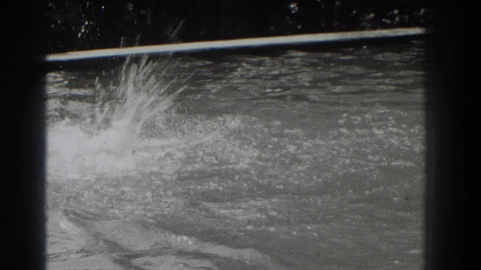 1937 8mm home-movie frame showing a high splash at the left side of a Southampton pool, with the swimmer mostly obscured.