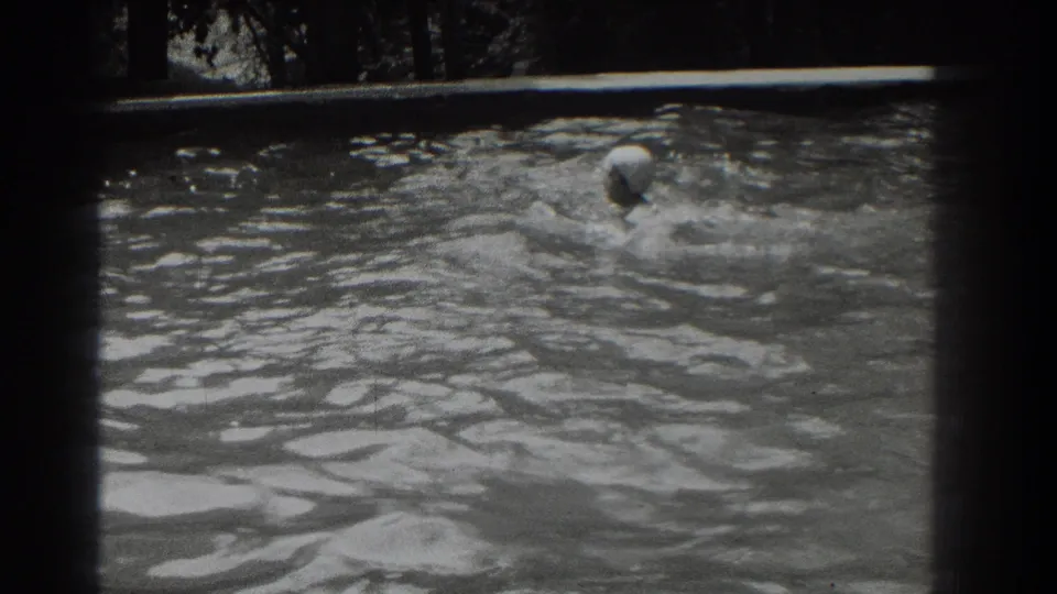 Near the end of the clip, the white-capped swimmer turns or strokes through the pool while water splashes around her.