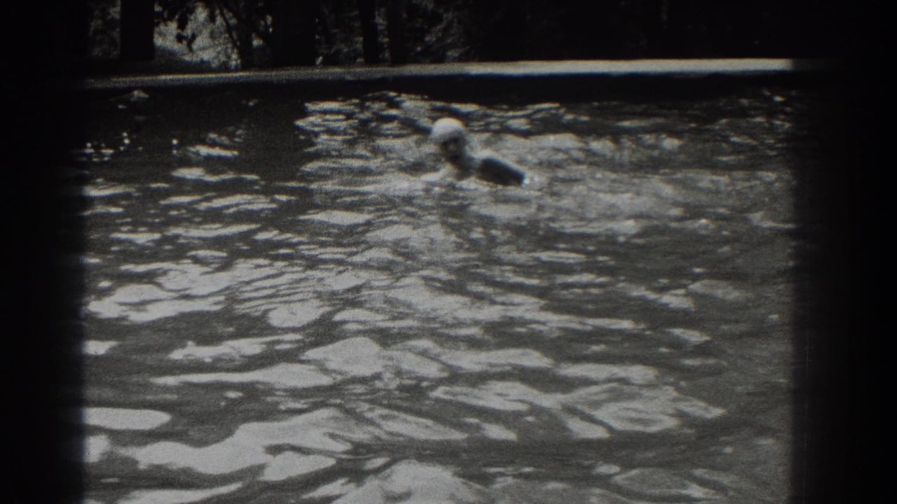 Swimmer moving through rippling outdoor pool water.
