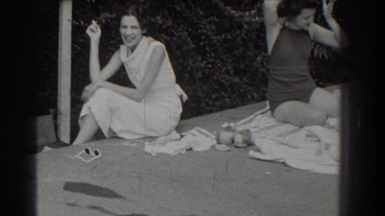 1937 Southampton frame of a smiling woman in a light dress holding a cigarette beside a woman in a dark swimsuit.
