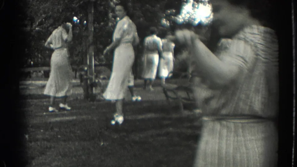 A close foreground figure partially obscures women in white dresses standing and walking in a 1937 park scene.