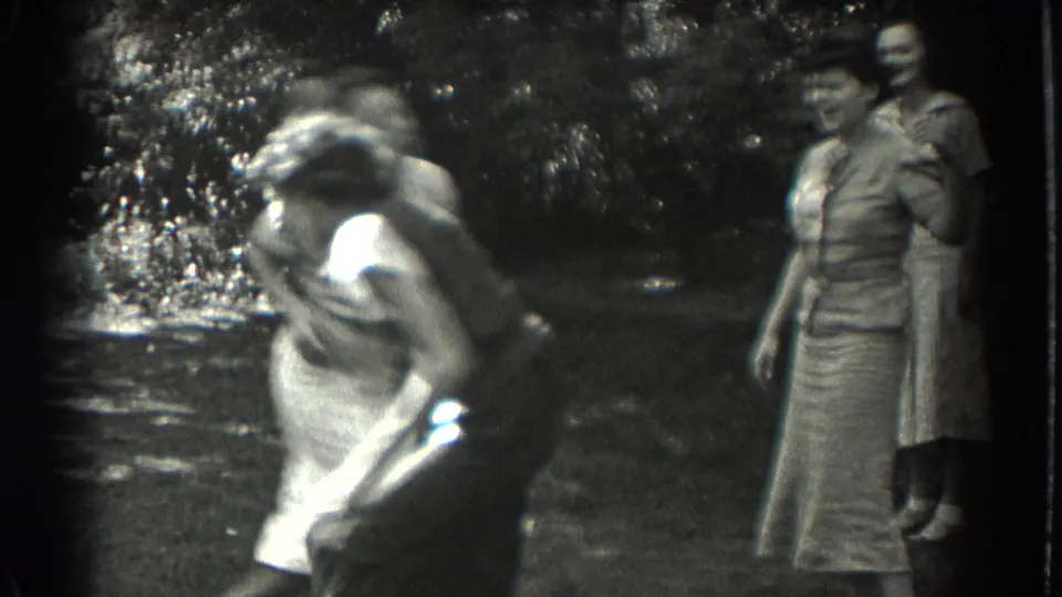 A woman bends or spins forward during the playful Southampton park scene as two other women watch nearby.