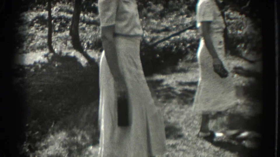 Adult women in light summer clothing move through a shaded Southampton garden, with figures partly cropped by the 8mm frame.