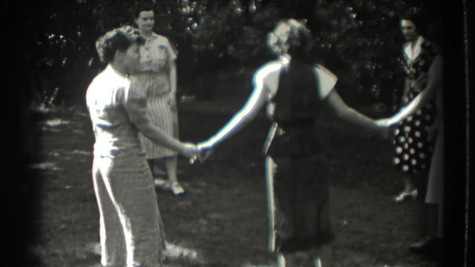 Women in a Southampton backyard clasp hands during a 1937 garden dance or circle game.