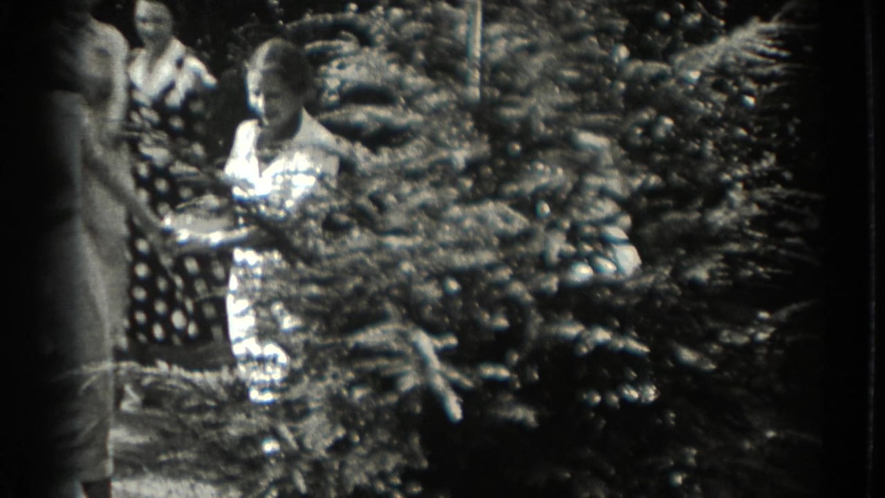 Women and teenage girls stand near shrubs during the backyard game.