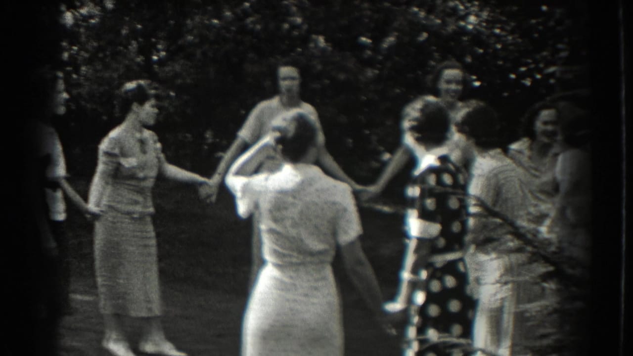 Women face inward while holding hands in an outdoor circle.
