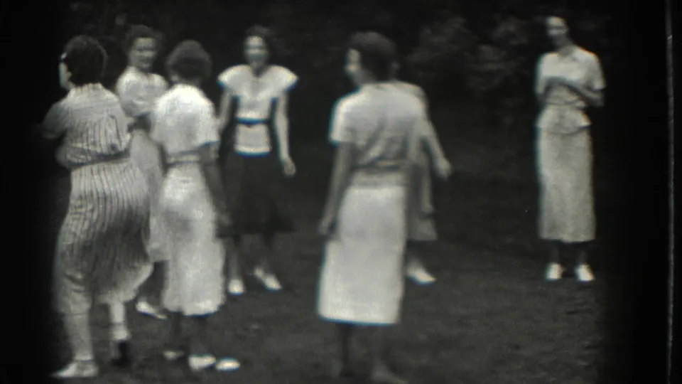 Adult women in 1930s-style dresses and skirts stand together on a lawn in Southampton, New York.