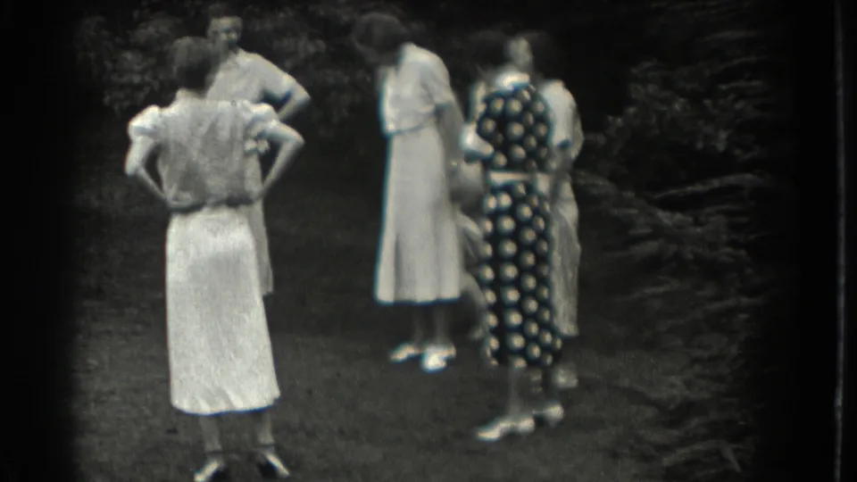 Adult women in period dresses gather on the lawn, seen mostly from behind in 1937 Southampton home-movie footage.