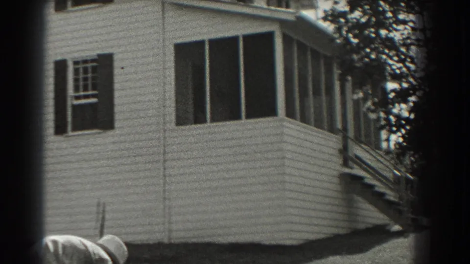 1937 Southampton home exterior showing white siding, a screened porch, a window, and exterior stairs beside the yard.