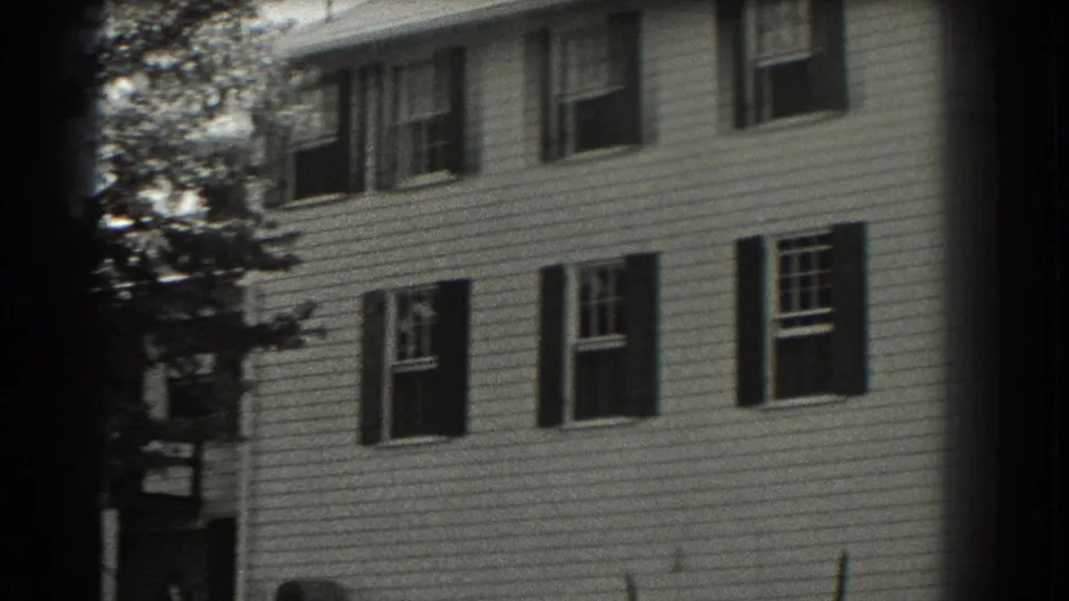 1937 Southampton frame showing the side elevation of a white clapboard house with dark shutters, windows, and trees at the edge of the yard.