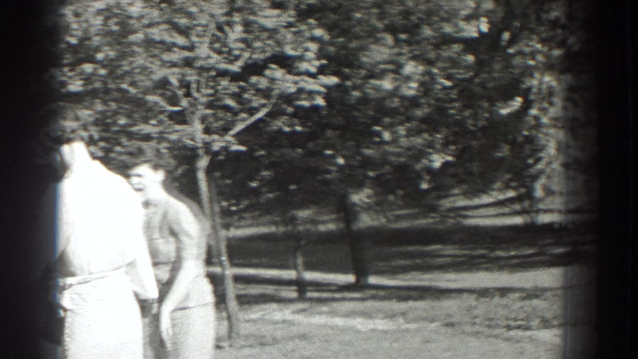Two women standing outdoors near trees, one partly overexposed at the edge of the frame.
