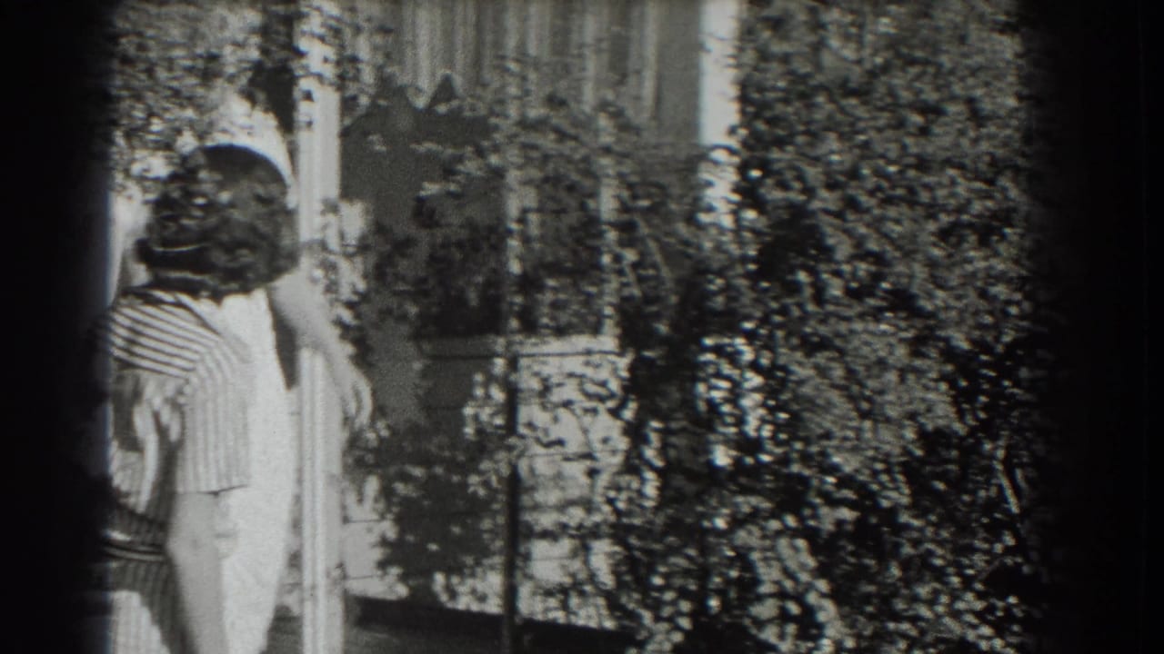 Two adult women in light dresses stand near leafy planting and a house or porch exterior in the supplied 1937 Southampton footage.