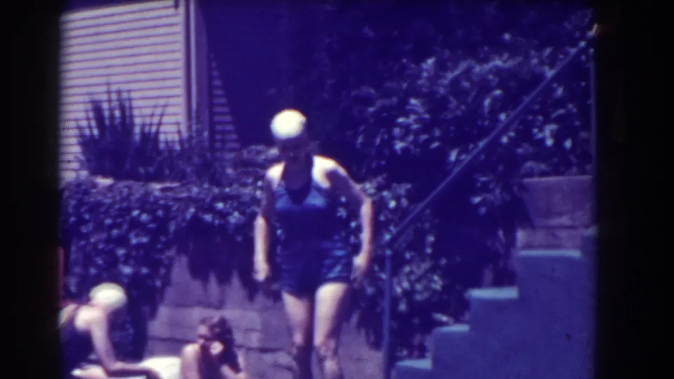 Southampton 1937 frame with a swimmer walking poolside while other women sit at the edge.