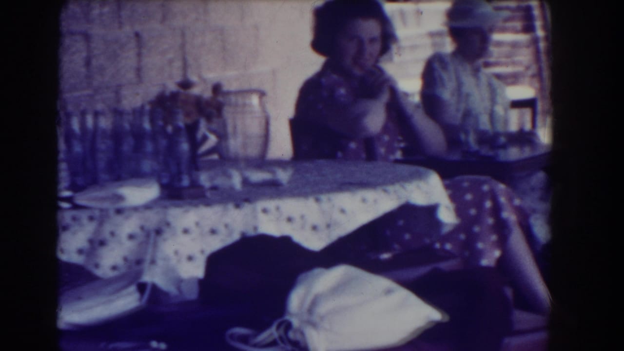 Young women sit near a table covered with bottles and a polka-dot cloth.