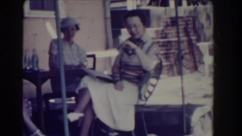 In 1937 Southhampton, New York, three women in summer clothing sit together on a porch while one holds a book.