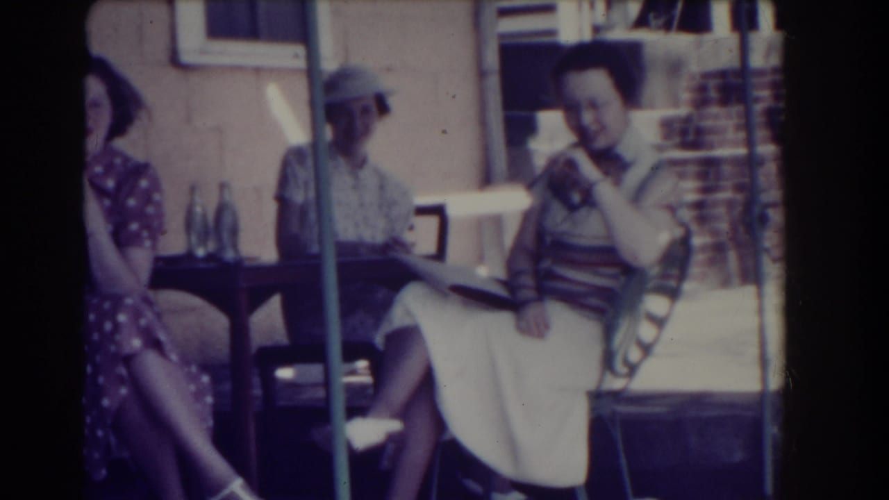 Women in 1930s attire sit on a shaded Southhampton porch, with one woman in a polka-dot dress partly visible.