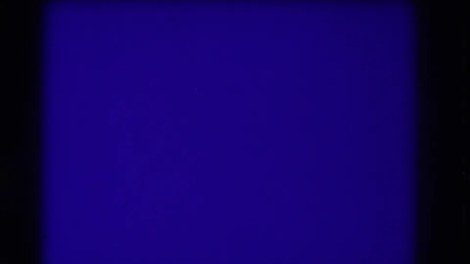 A blue leader-like 8mm frame fills the view, with dark side borders and subtle film grain.