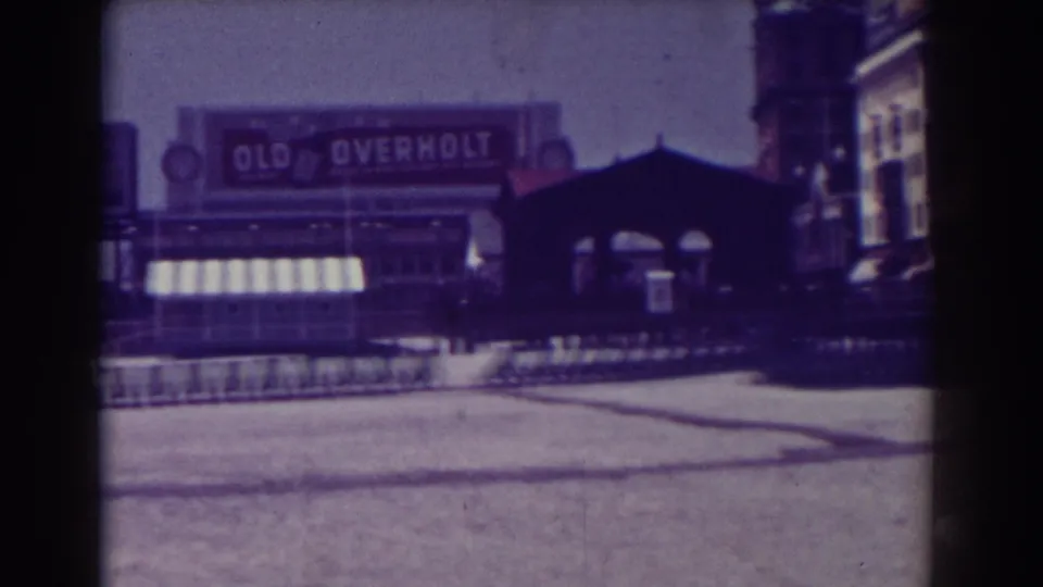 1938 Atlantic City footage frame showing a row of training sleds, a striped awning, and the Old Overholt billboard behind the field.