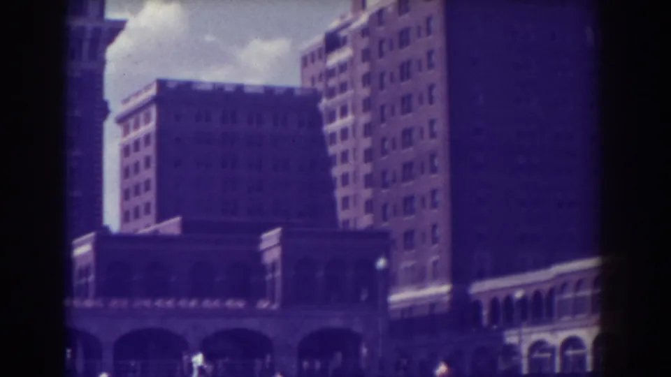 1938 Atlantic City footage looking upward at multi-story masonry buildings with arched storefront or arcade details near street level.