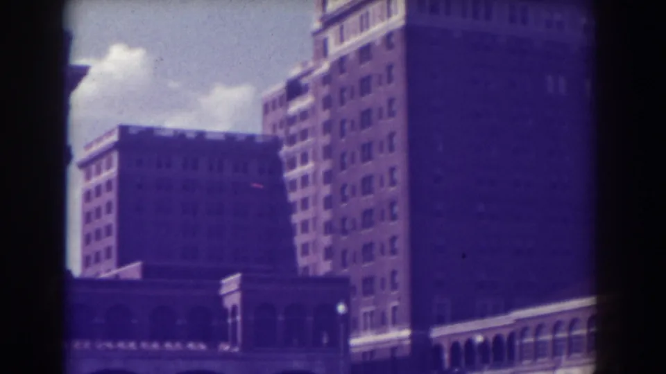 Atlantic City resort-era buildings appear in soft 1938 home-movie footage, with many windows, arched lower levels, and strong film-edge shadowing.