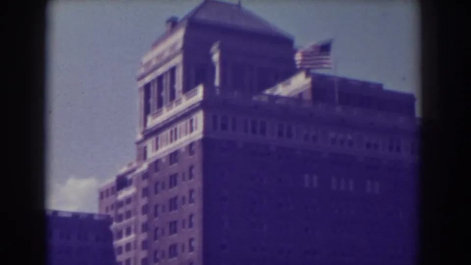 1938 Atlantic City 8mm frame showing a rooftop pavilion, flag, and broad facade of a large city building.