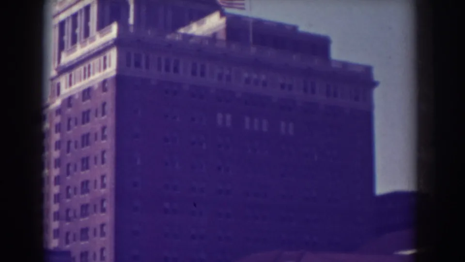 1938 Atlantic City exterior view of the upper portion of a large multi-story building with a flag and sunlit roofline.