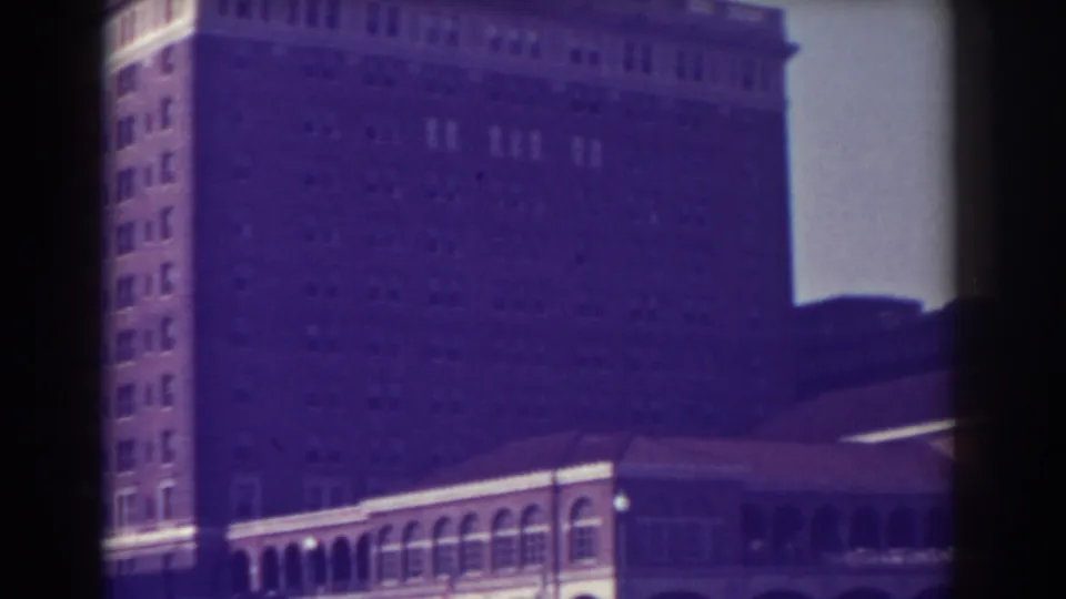 1938 Atlantic City home-movie frame with the tall building, arched foreground structure, and dark film-edge framing.