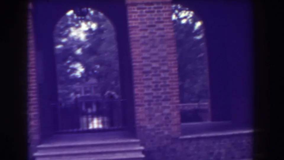 Atlantic City brick entrance detail with an arched passage, steps, white-trimmed window, and trees visible through the opening.