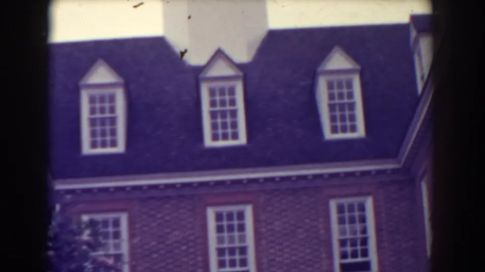 1938 Atlantic City 8mm view of dormer windows, a dark roof, and brick walls with white-trimmed windows below.