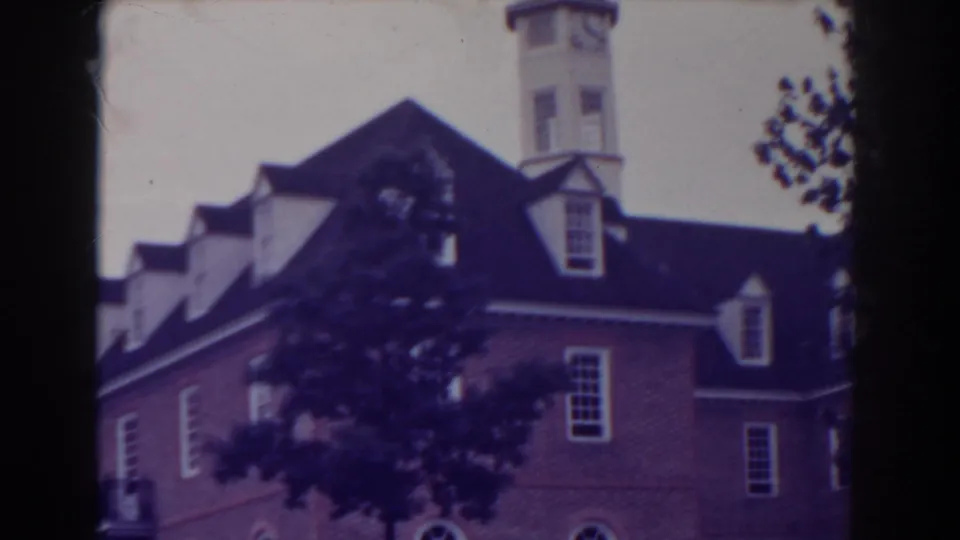 1938 Atlantic City frame showing a brick building with dormers and arched windows, partly screened by trees.