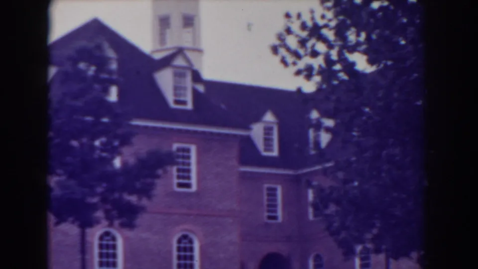 1938 Atlantic City 8mm frame of a stately brick building, with dormer windows and trees framing the facade.