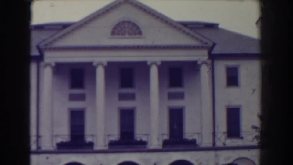 1938 Atlantic City frame centered on the white building facade, showing four columns, a triangular pediment, arched lower level and dark window openings.