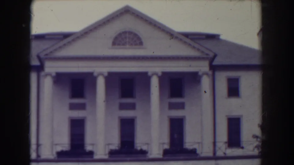 1938 Atlantic City home-movie frame showing a white classical-style building with columns, a triangular pediment, and an arched upper window.