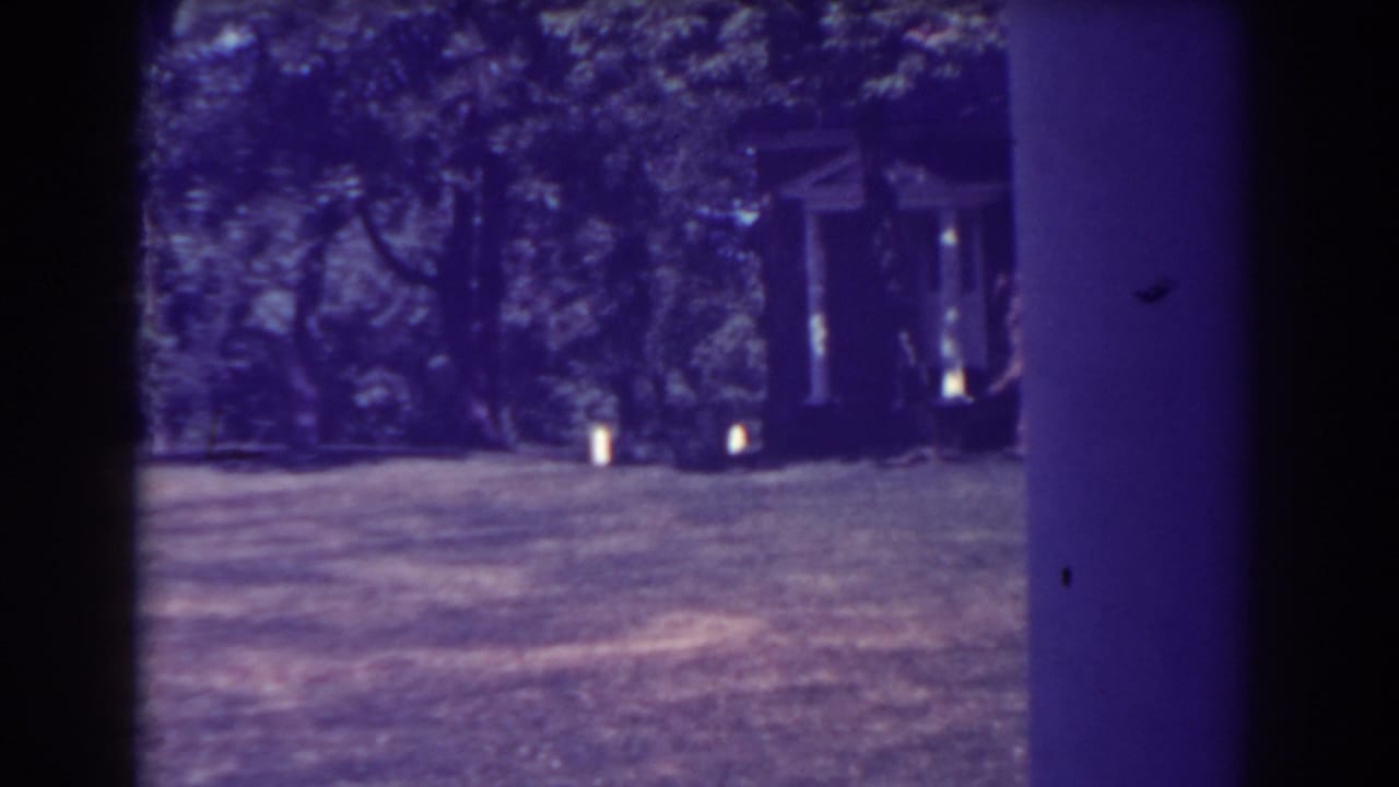 Grassy overlook with trees and a small structure partly visible near the left side.