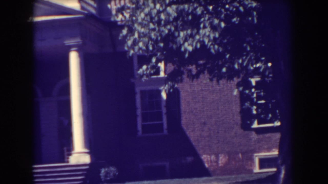 1938 Atlantic City exterior view of a brick columned building partly shaded by trees.